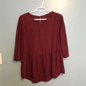 Loose fitted burgundy peplum top. Size XS.
